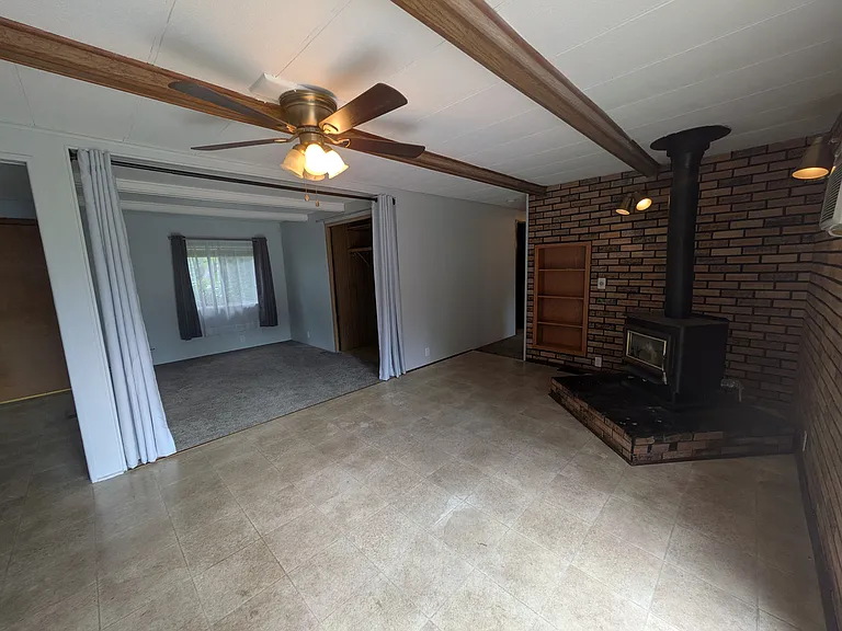 Wood stove and siting room off of home's back entrance from the deck.