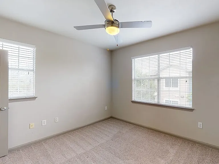 Spacious apartment bedroom with plush carpet flooring