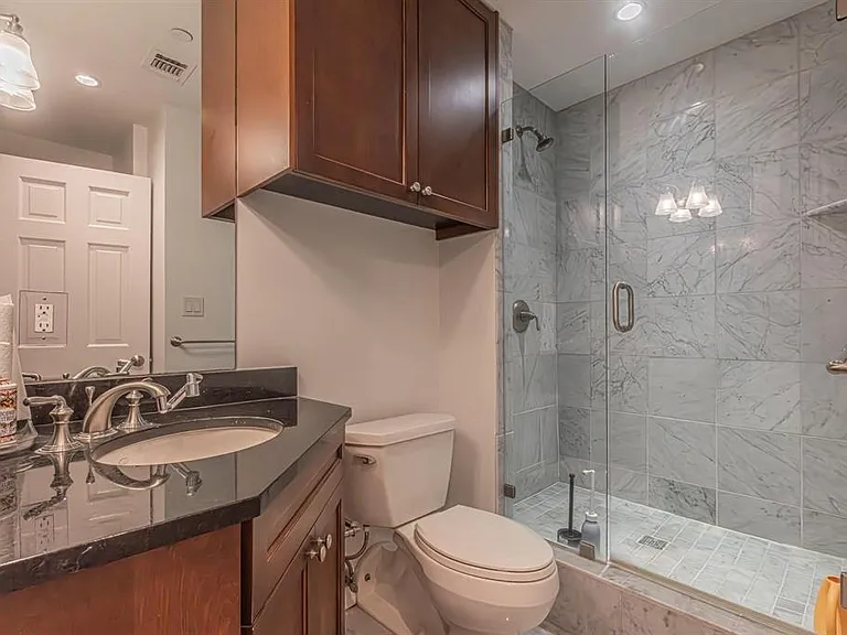 Contemporary bathroom featuring a glass-enclosed shower with tiled walls and flooring