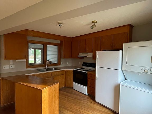 The kitchen, includes eletric stove top and oven, fridge, and also the laundry and drying machines.