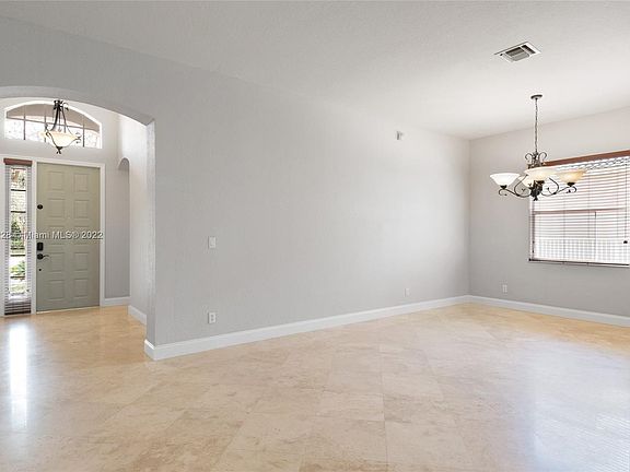Foyer and Formal Dining Area with Travertine flooring and high ceilings.
