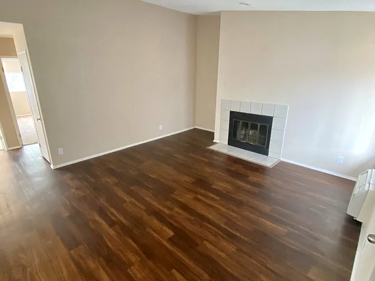 Beautiful wood plank style flooring and fire place in living room of Grande Vista Apartments.