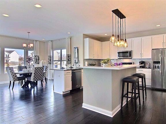 VIEW OF THE SPACIOUS KITCHEN AND CAFE ROOM...NOTICE THE HUGE GOURMET ISLAND..PANTRY IS TO THE RIGHT NOT SHOWN. THIS KITCHEN IS AND CAFE ROOM ARE NOT BASE PRICE. YOU CAN ADD THESE OPTIONS FOR ADDITIONAL COST