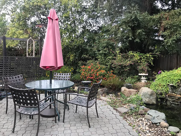 Patio near water fall (now pond-less) that provides warm morning sun and relaxing afternoon shade.
