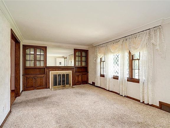 Custom built-ins, beautiful mirrored fireplace, oak hardwood flooring under the carpeting.