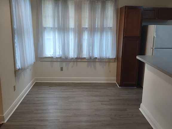 Between kitchen and living. Room for small dining table.