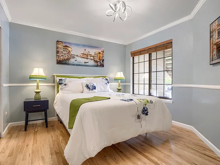 Primary Bedroom - Crown molding, chair rail detailing, and custom millwork add timeless architectural character and refined craftsmanship to this beautifully appointed bedroom.