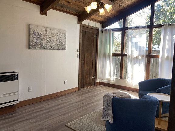 living room with vaulted ceiling and wall of windows