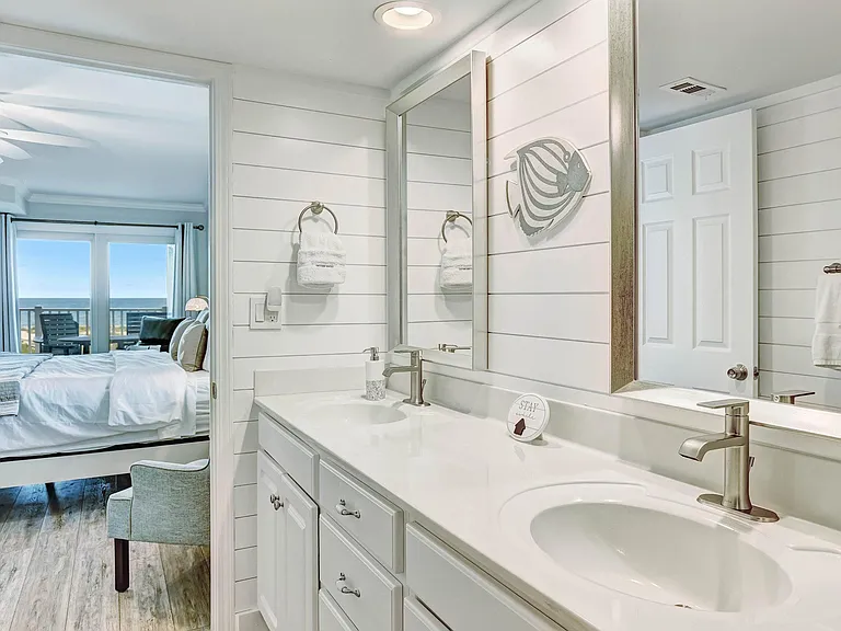 En suite primary bathroom with double vanity and walk in shower.