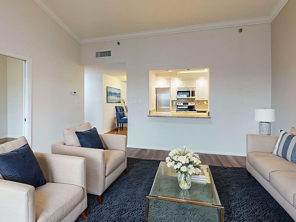 Inviting living room with elegant furniture, cozy seating, and a modern kitchen view. Bright, spacious, and perfect for relaxation.