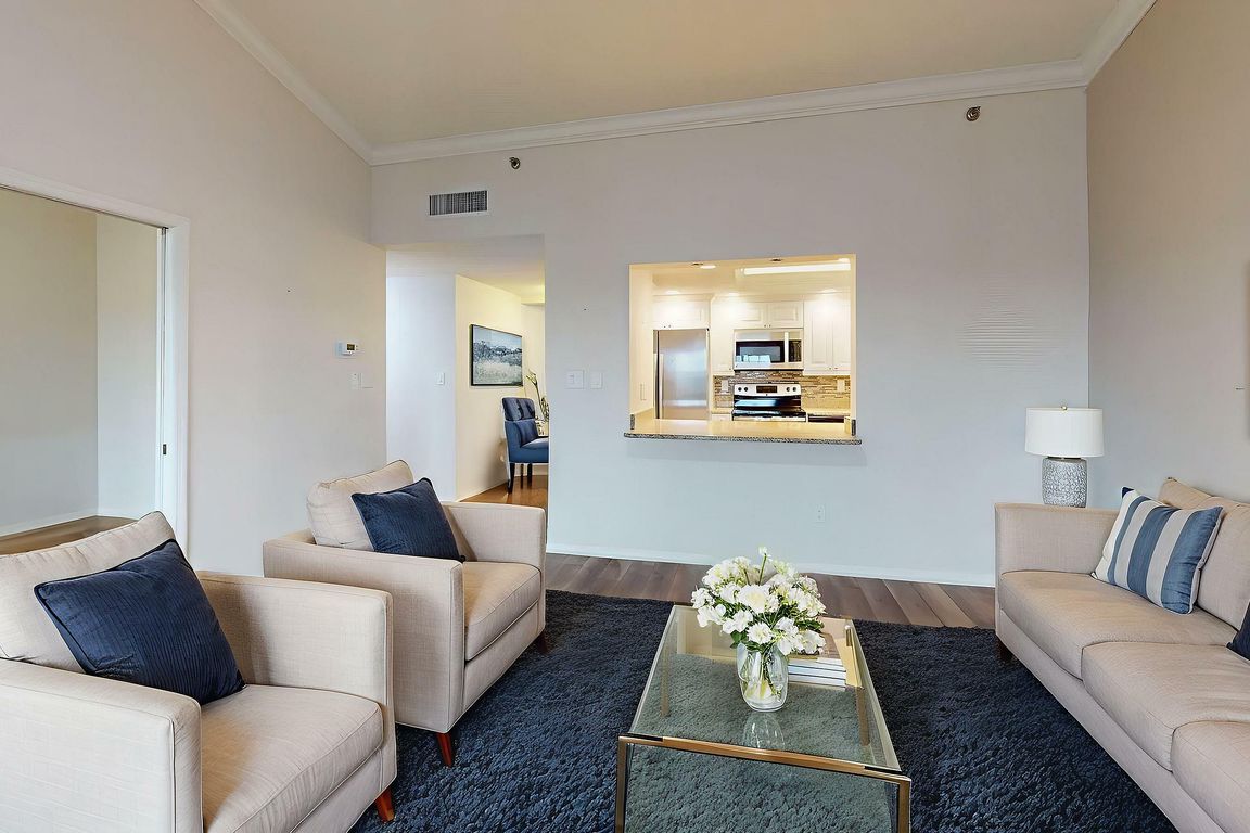 Inviting living room with elegant furniture, cozy seating, and a modern kitchen view. Bright, spacious, and perfect for relaxation.