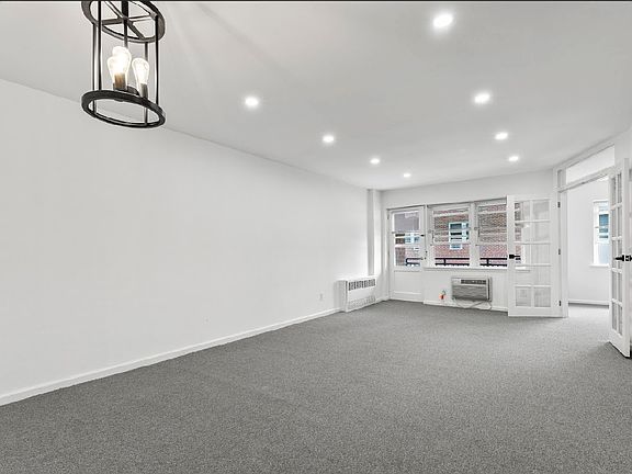 Living room/dining area with doors to second bedroom and door to terrace.