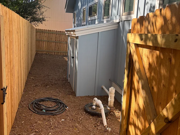 Back of house with water softener shed/storage.