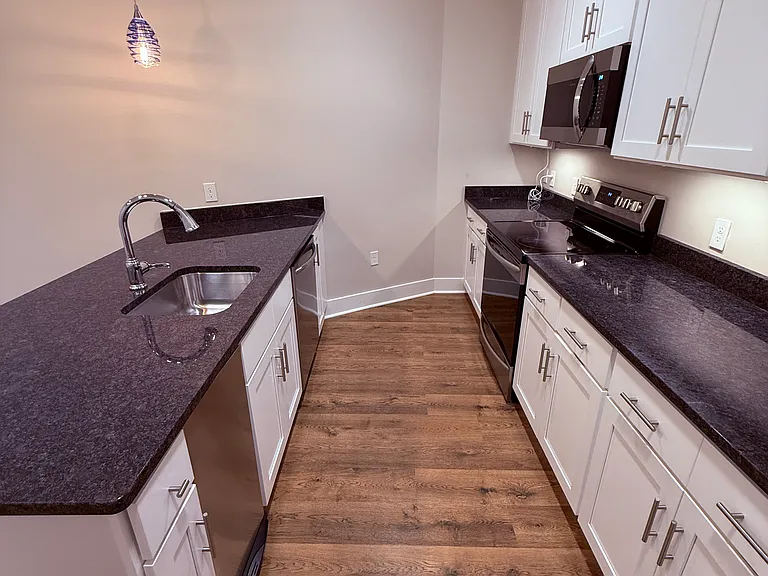 Kitchen with dishwasher, garage compactor, microwave, oven, and refrigerator.