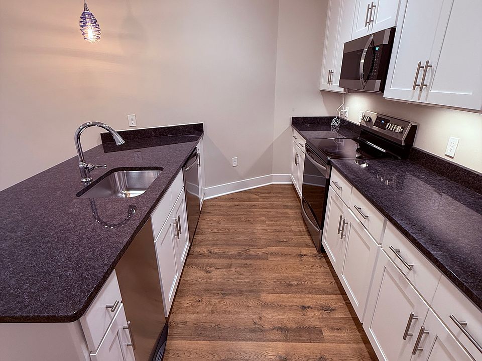 Kitchen with dishwasher, garage compactor, microwave, oven, and refrigerator.