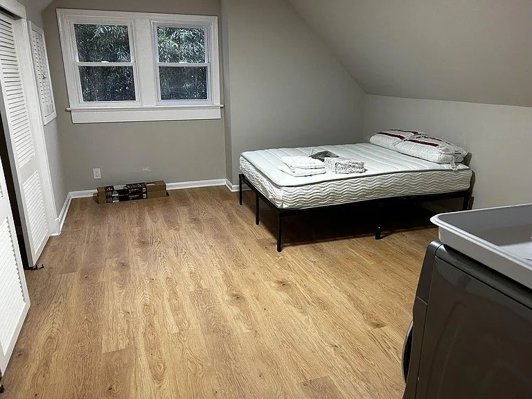 Private bedroom with wood-style flooring, a closet, and a window for natural lightideal for a full-size bed and essentials.