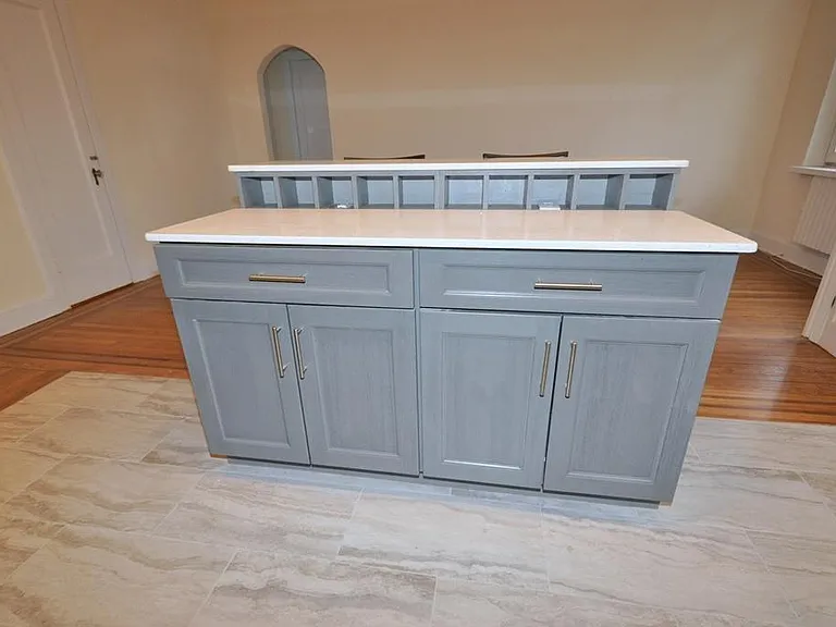 Renovated Kitchen with center Island, pendent lighting, Granite Counters, Stainless Steel Appliance including a dishwasher, range, microwave and refrigerator. The wall separating the eat-in-kitchen and living room have been removed and a center Island ins