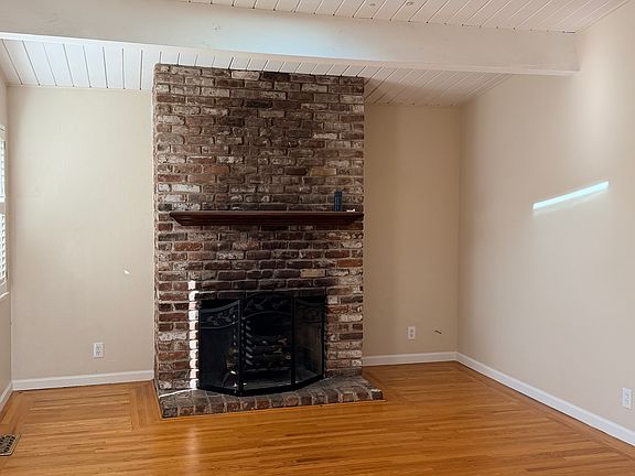 Living room with brick wood burning fireplace