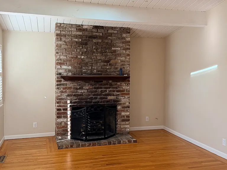 Living room with brick wood burning fireplace