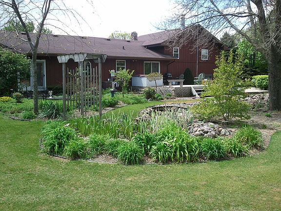 BACKYARD HAS RAISED WOODEN DECK, BRICK PATIO AND PERENNIAL SITTING GARDEN