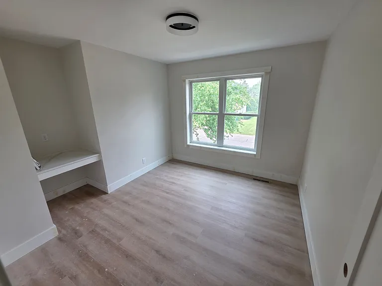 Front facing bedroom 1 with quartz desk nook and new Anderson windows.
