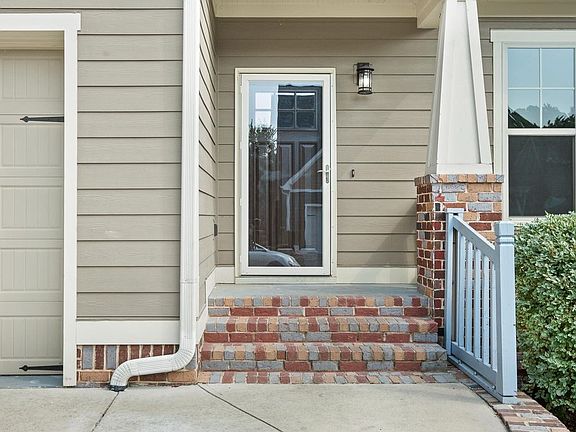 Front porch with glass screen door and front door with electronic keypad entry.