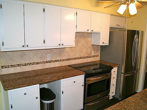 Kitchen boasts granite countertops, stainless steel appliances including "french door" refrigerator.