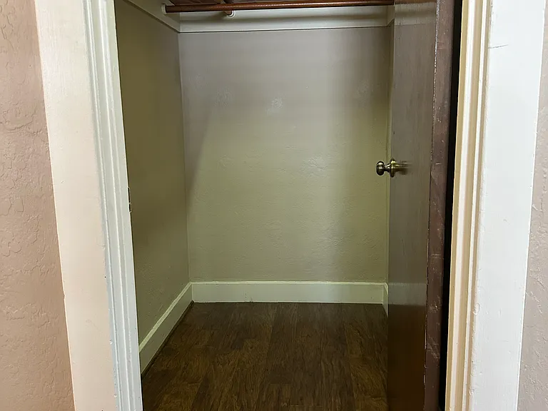 This walk-in closet is in the hallway opposite of the kitchen