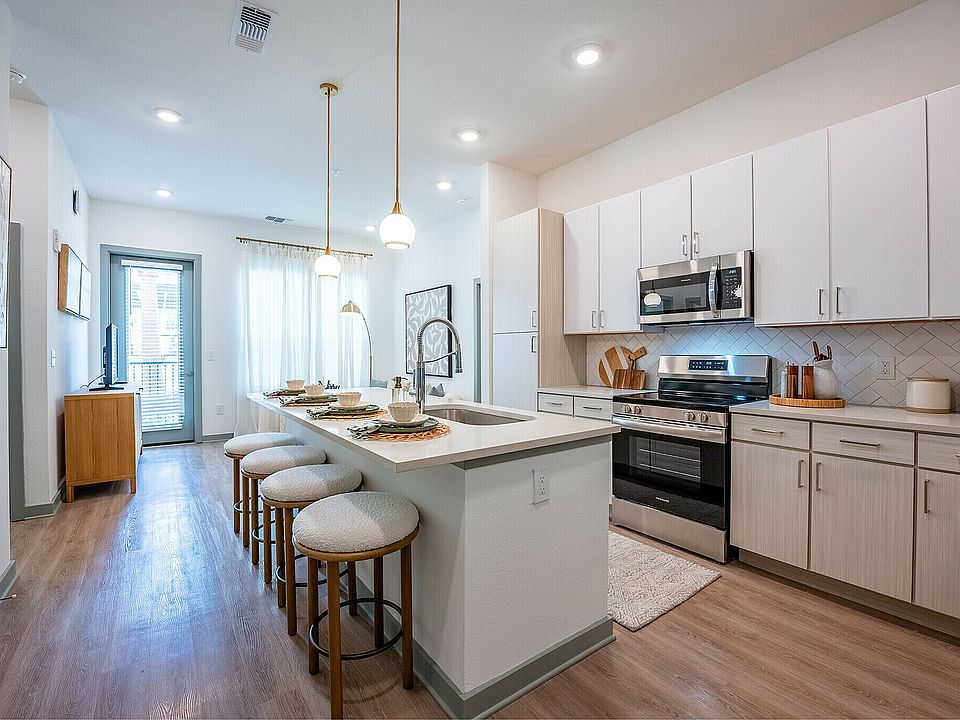 Modern apartment kitchen with sleek white cabinetry.