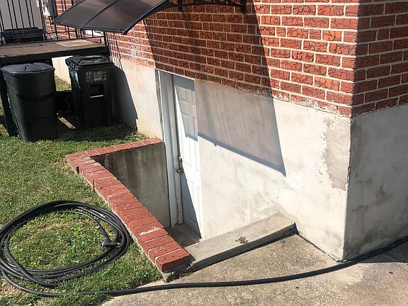 Entrance to shared basement area (unfinished) with W/D and storage