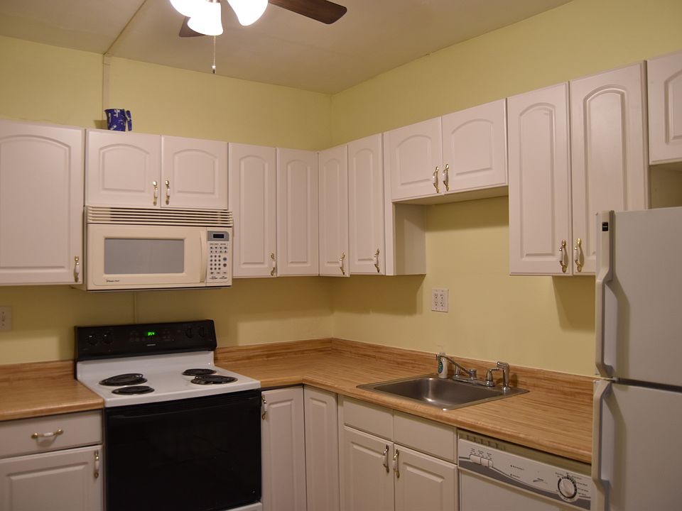 Kitchen with washer and electric stove and over the counter microwave