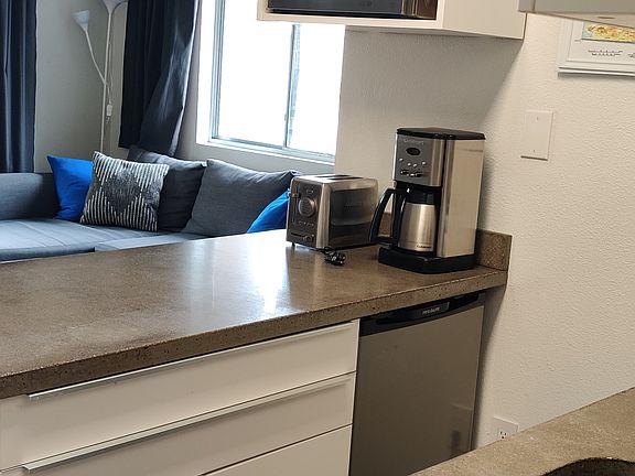 Kitchen with concrete countertops, microwave refrigerator, dishwasher, oven