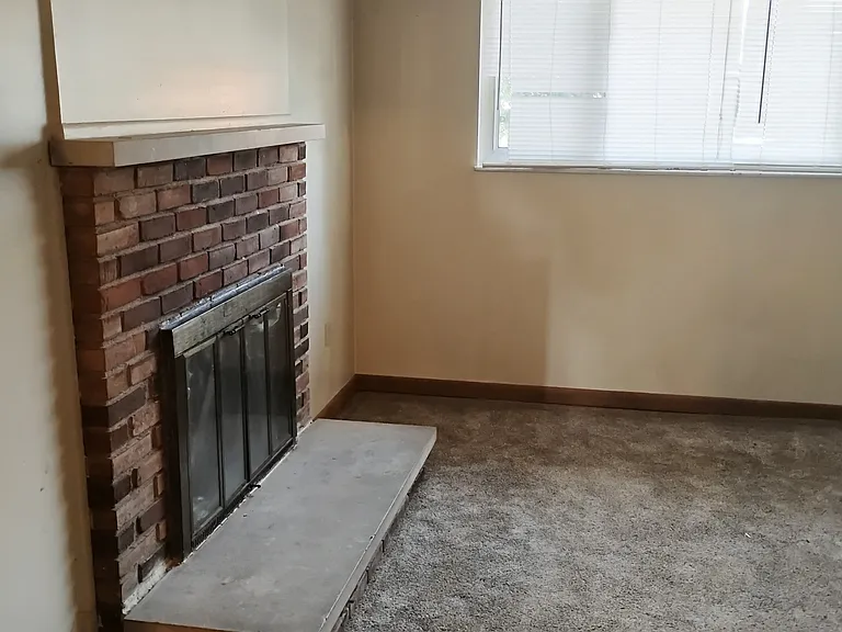 View of the fireplace from the washer and dryer hook-up utility-room which is the lower level entryway.