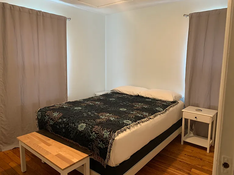 Bedroom with natural light and real hardwood floors.