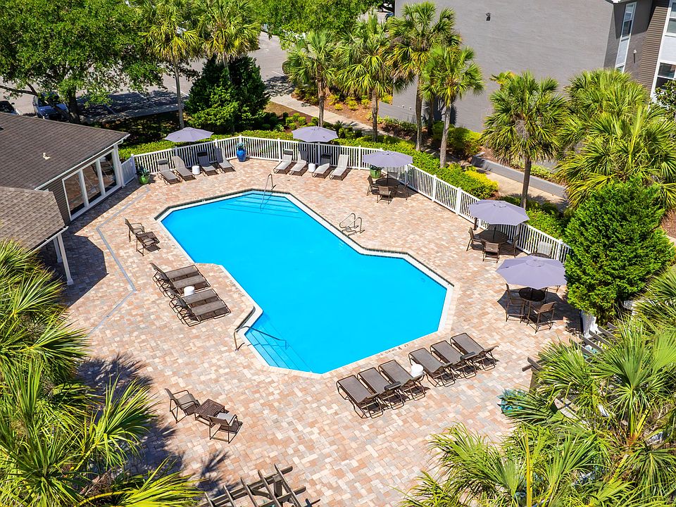 A stunning aerial look at The Enclave at Huntington Woods' sparkling swimming poolcomplete with spacious sundeck, lounge chairs, and shaded seating for the perfect day under the Florida sun.