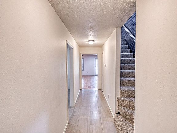 View from front door with stairs to bedrooms on right, entry to kitchen/dining room on left, and living room straight ahead. Not shown is door immediately to the right to the 1/2 bathroom.
