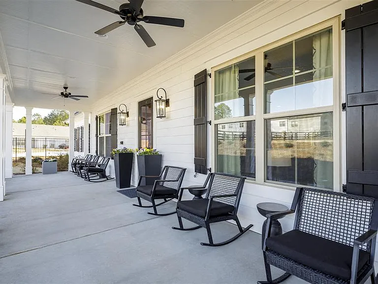 Clubhouse exterior porch with rocking chairs to relax and unwind.