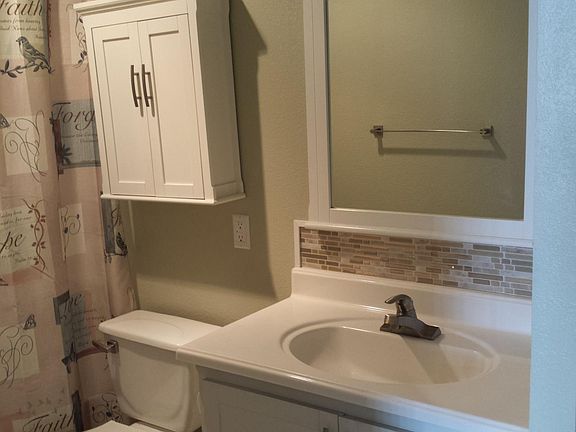 A122 - Bathroom vanity has storage room under sink and in drawers (not shown). More storage in cabinet over commode.