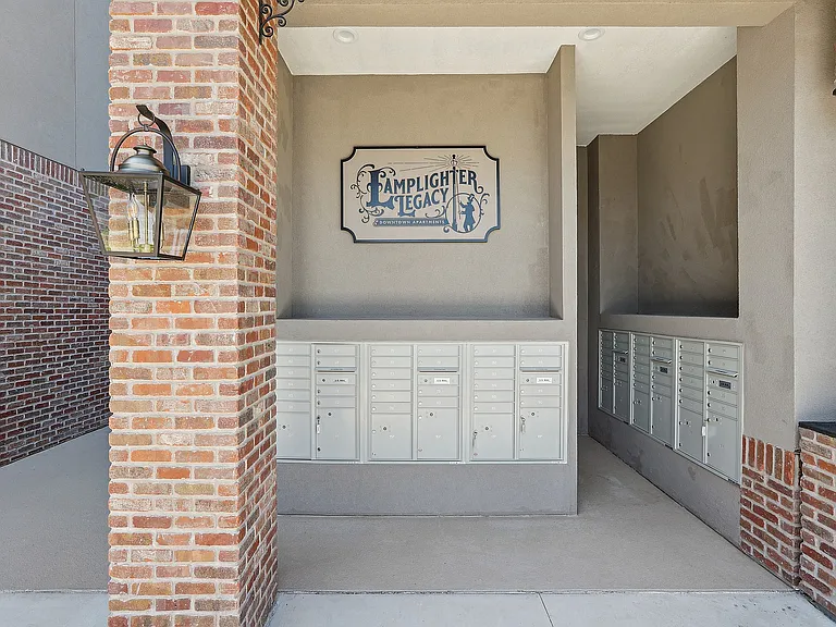 Elegant brick and stucco exterior featuring modern mailbox units at a chic downtown apartment complex.