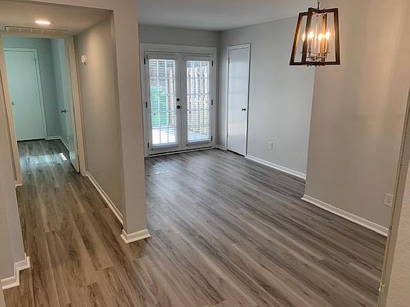 A view down the hall to the master bedroom on the left. Breakfast room under the light and a sunroom/office further back with french door access to the back patio