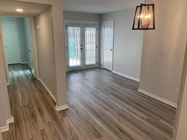 A view down the hall to the master bedroom on the left. Breakfast room under the light and a sunroom/office further back with french door access to the back patio