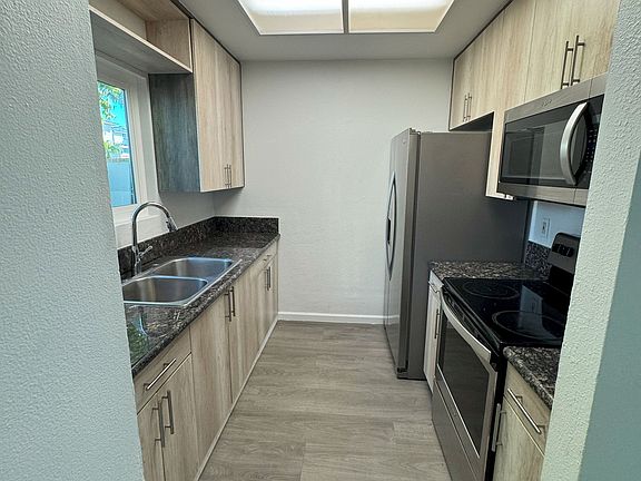 Kitchen with refrigerator, microwave and stove.