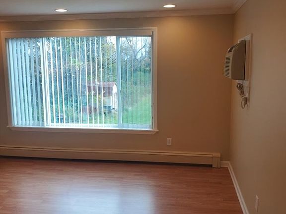 Living room with wall AC unit.