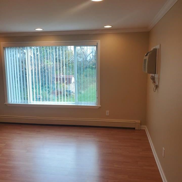 Living room with wall AC unit.