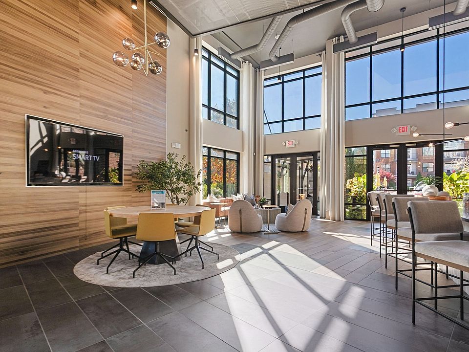 Sunlit clubroom with seating and courtyard views for a warm welcome home