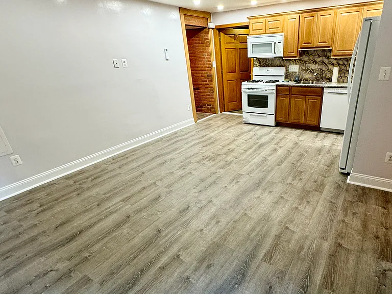 living room, dining room, kitchen with no furniture.