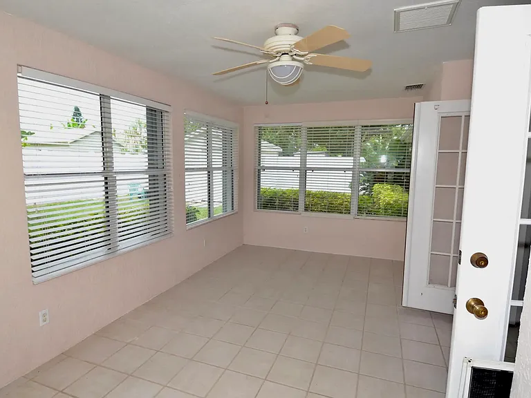 Florida room, tile floor, opens to large patio with large shed.