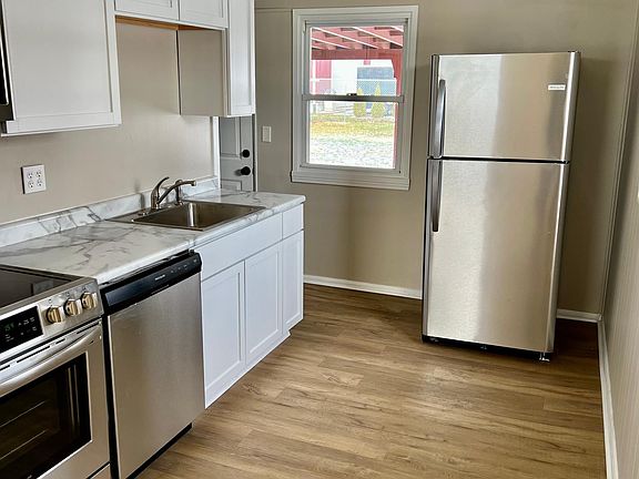Exterior door from kitchen leads to carport. There is also an exterior storage room/ workshop.
