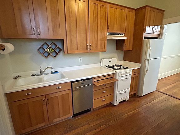 Kitchen, beyond living space. 
Dishwasher, gas range, refrigerator and cabinets