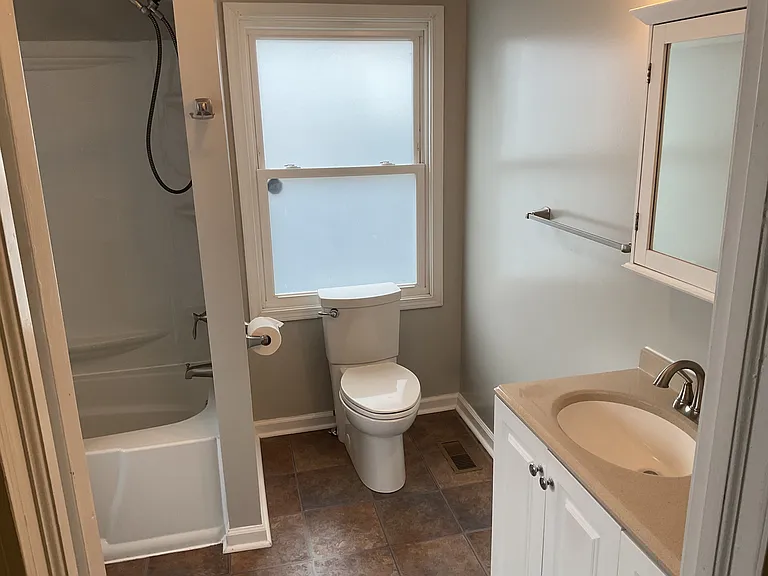Main Floor Bathroom with Tub/Shower, Spacious Vanity and Privacy windows.